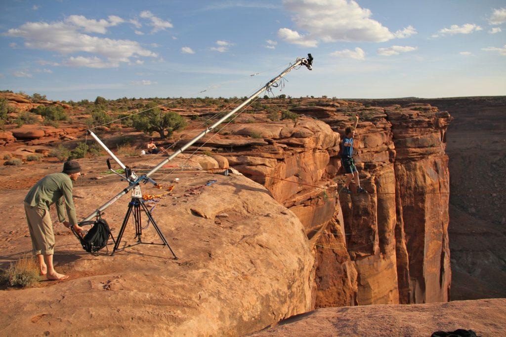 Un caméraman filme un cascadeur à l'aide d'une caméra fixée sur une grue.